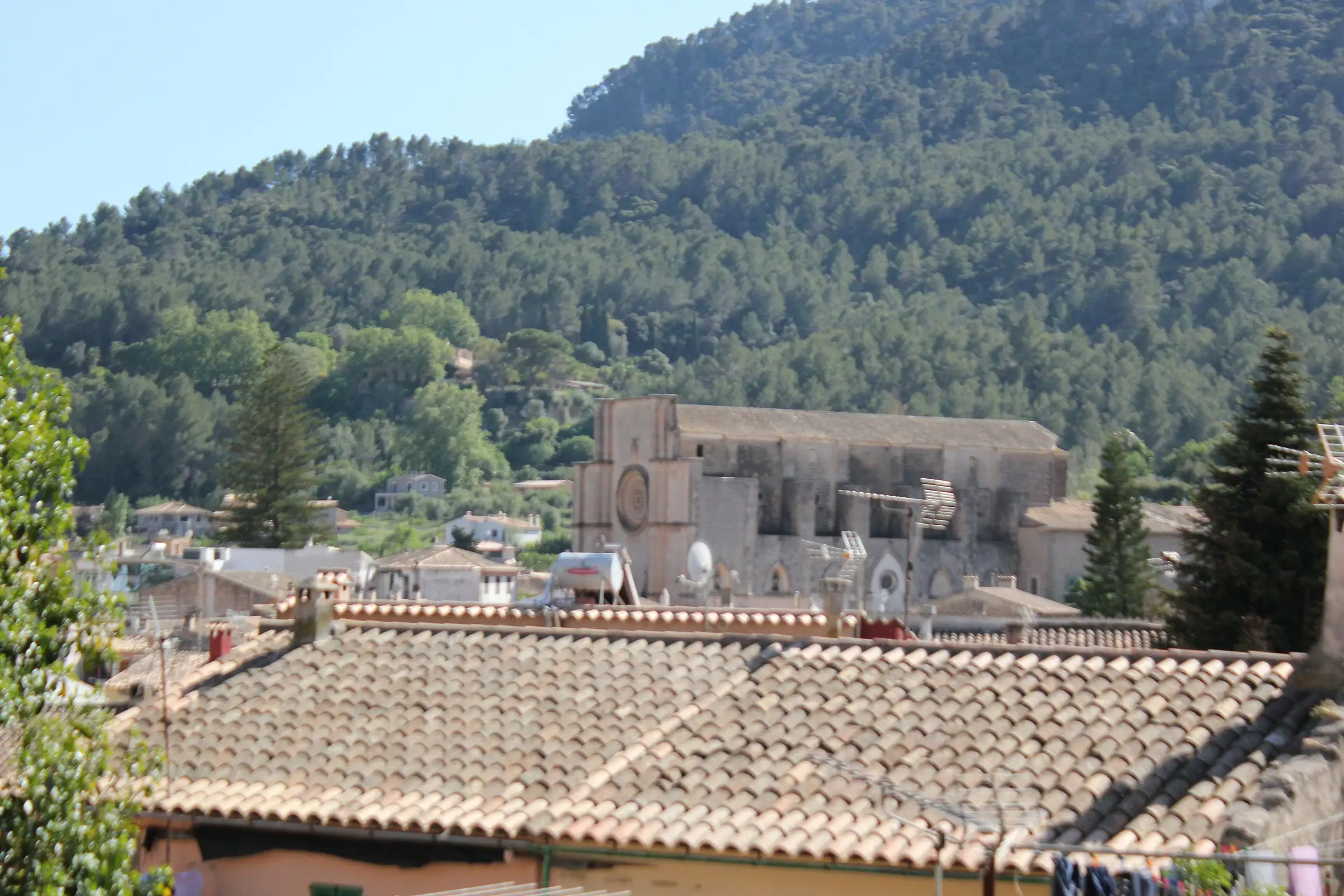 Les toits d'Esporles et l'église Sant Pere au pied des collines boisées