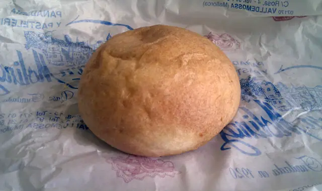 Une coca de patata posée sur le papier d'une pâtisserie de Valldemossa