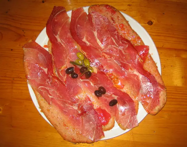 Tranches de pain à la tomate garnies de jambon cru et d'olives