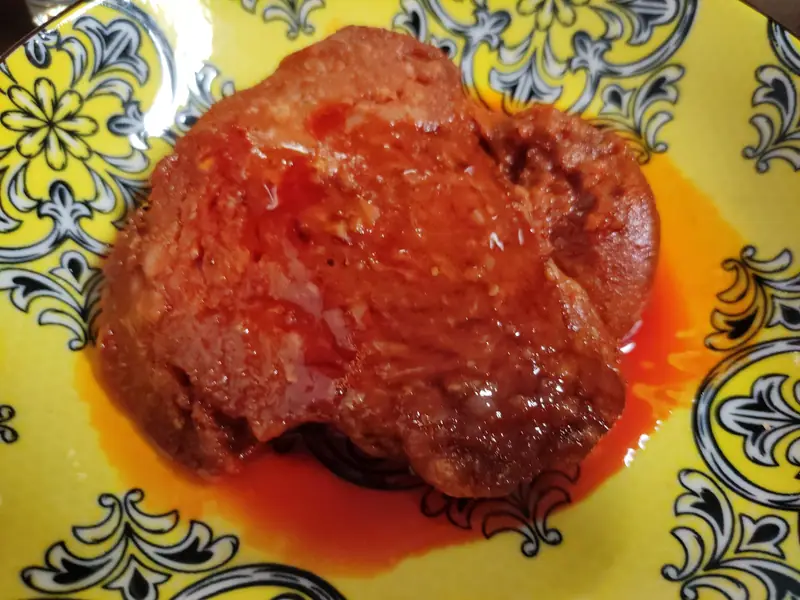 Une sobrassada chaude nappée de miel dans une assiette décorée