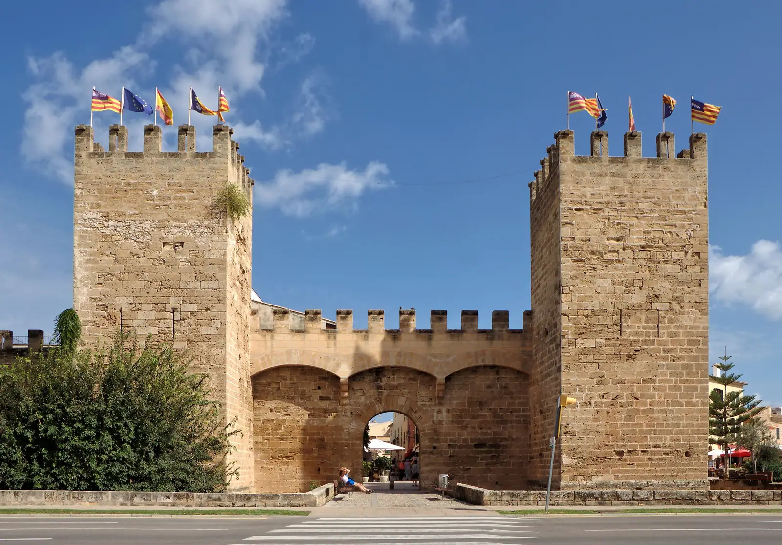 La porte fortifiée des remparts d'Alcúdia, deux tours crénelées sous le ciel bleu