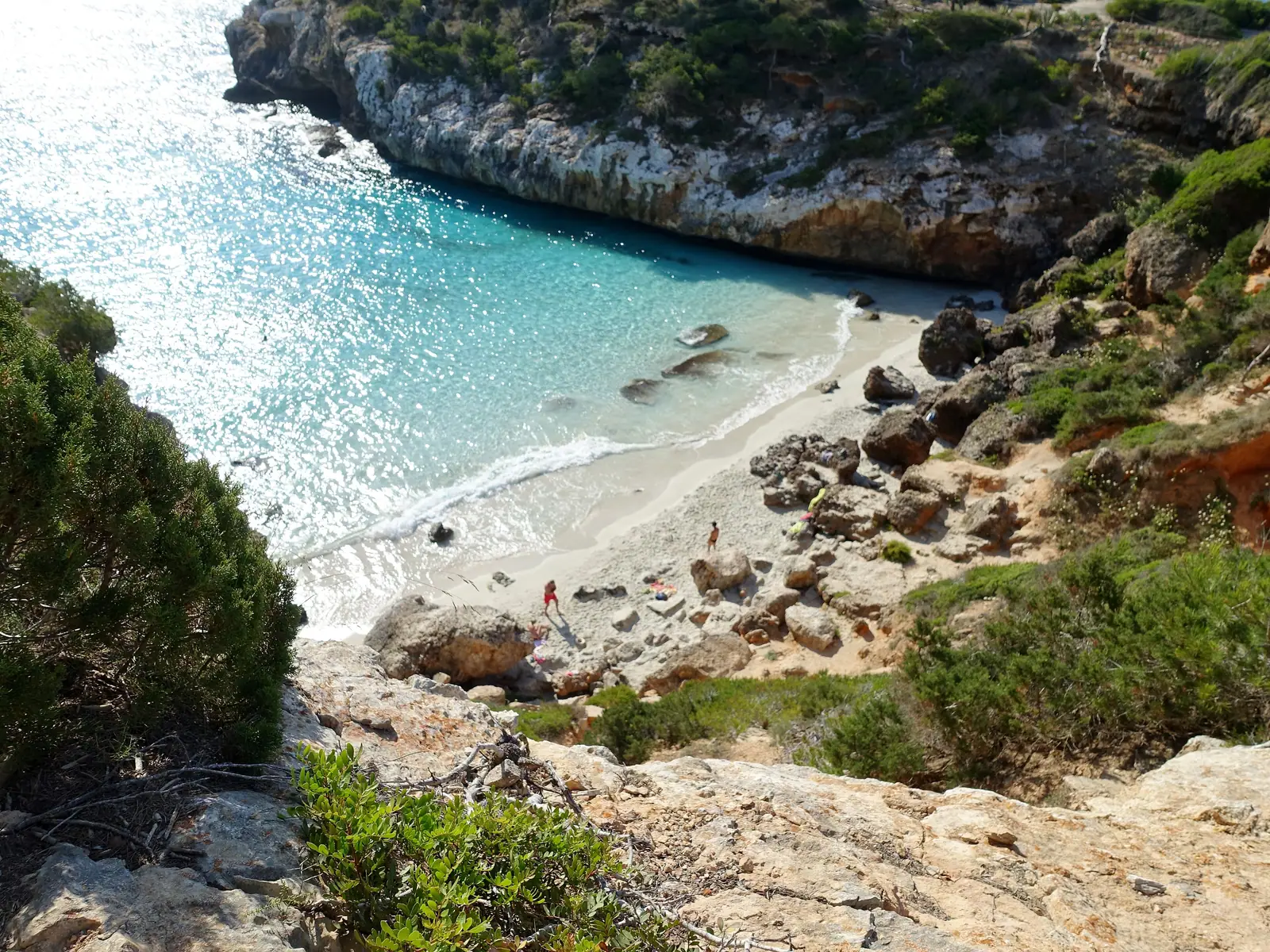 La crique de Caló des Moro, eau turquoise et sable clair entre des rochers boisés