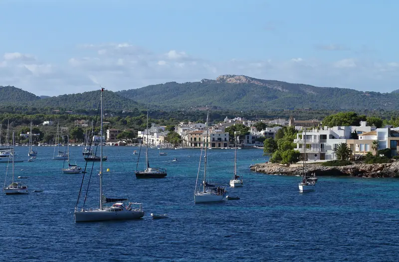Voiliers au mouillage dans la baie de Portocolom, collines au loin