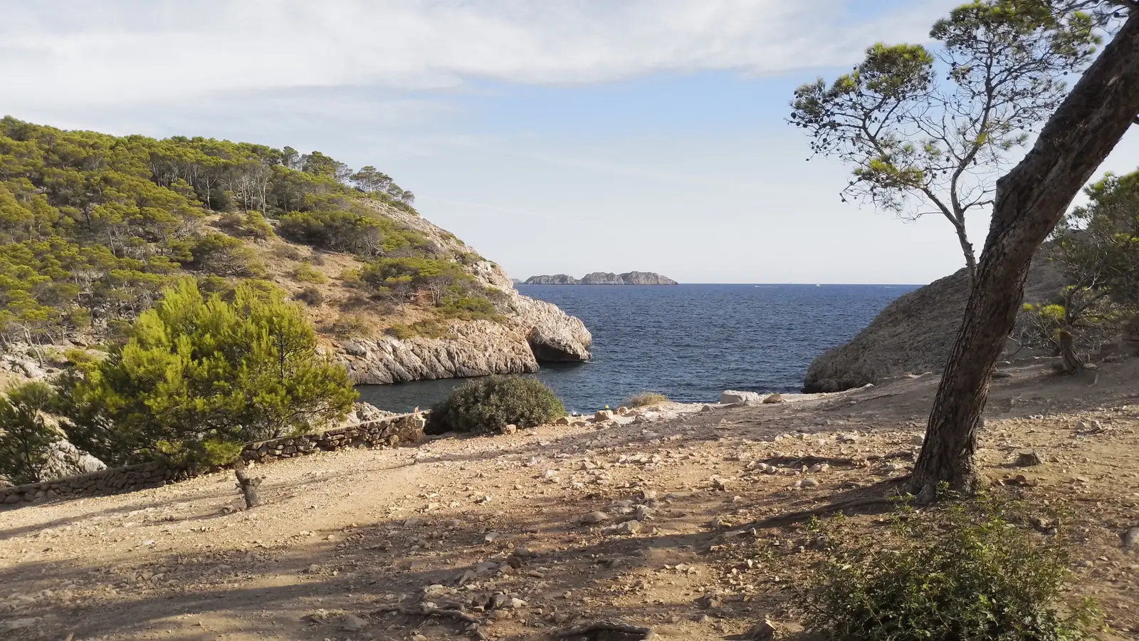 Le bras de mer de Caló d’en Monjo vu depuis le sentier, entre pins et falaises