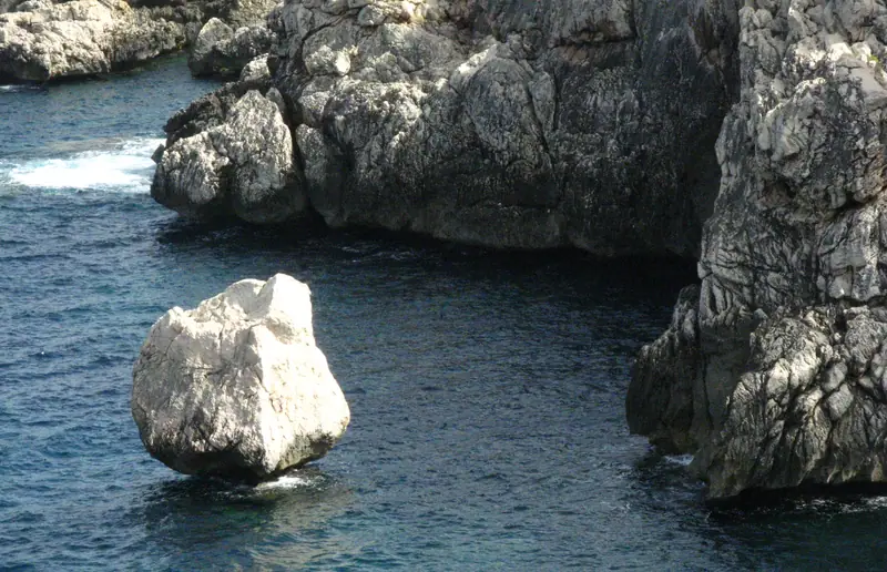 Rochers calcaires et eau sombre sur la côte entre Deià et Llucalcari