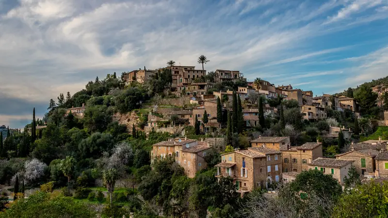 Les maisons de pierre de Deià étagées sur leur colline, sous un ciel nuageux