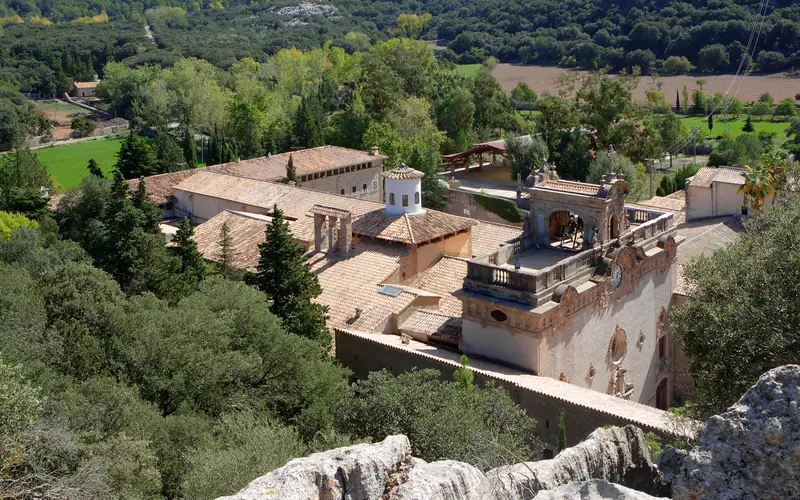 Le sanctuaire de Lluc entouré de forêt, vu depuis la colline du Rosaire