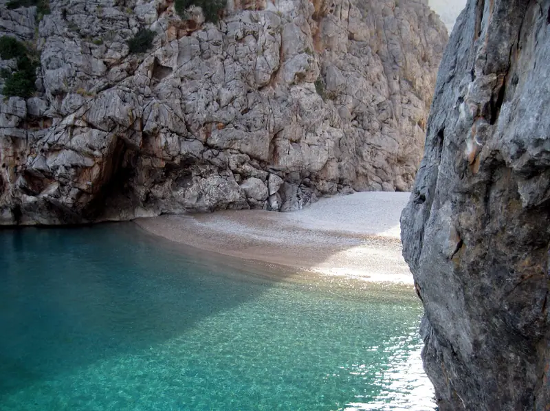 La crique de galets du Torrent de Pareis et son eau turquoise entre deux parois