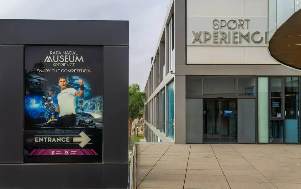 Panneau directionnel et façade extérieure du Rafa Nadal Museum Xperience à Manacor.
