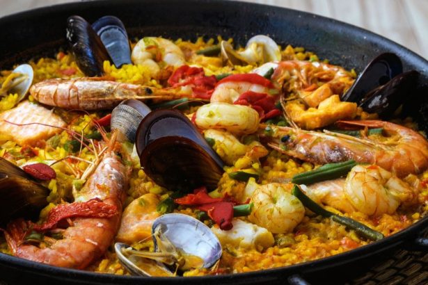 Paella traditionnelle aux fruits de mer à Majorque avec crevettes, moules, palourdes et riz safrané