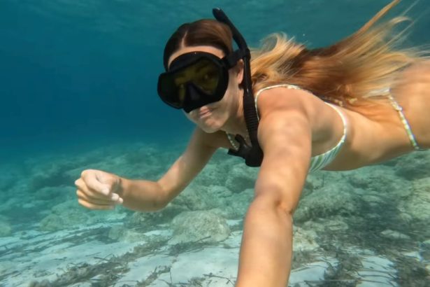 Femme faisant du snorkeling dans une eau turquoise à Majorque au-dessus de fonds rocheux