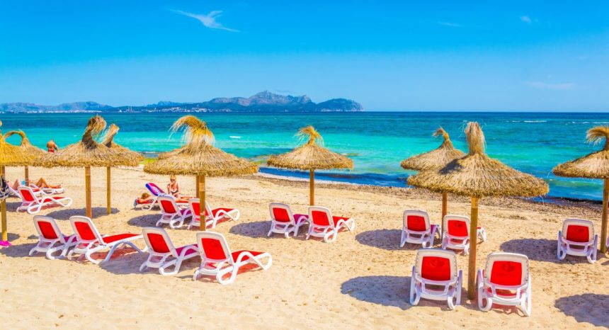 plage de Can Picafort à Majorque avec parasols en paille et mer turquoise