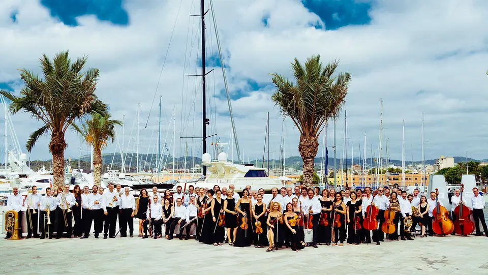 Photo : ComunicacioCesar, CC BY-SA 4.0, via Wikimedia Commons L'Orquestra Simfònica de les Illes Balears réunie sur le port de Palma
